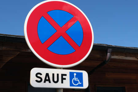 Road sign indicating in French prohibited to park except disabled peopleの写真素材