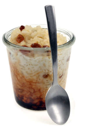 Ramekin of rice pudding with a spoon close-up on white backgroundの写真素材
