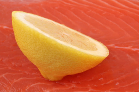 Lemon slice on raw salmon close up