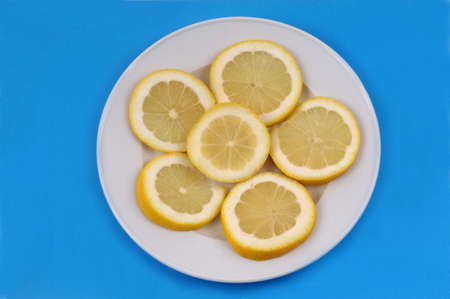 Lemon slices in a plate on a blue backgroundの写真素材