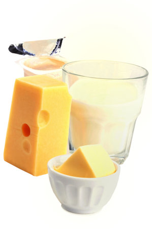 Gruyere cheese, butter, yogurt and glass of milk close-up on white backgroundの写真素材