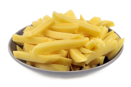 Plate of raw french fries in a plate close-up on white background