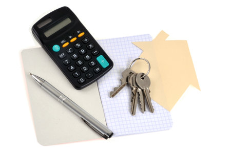 Real estate project concept with a bunch of keys, pen, notebook and calculator on white backgroundの写真素材