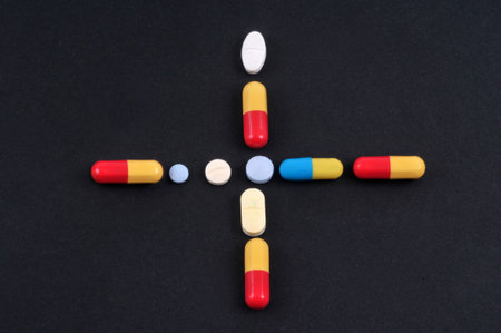 Cross of various drugs on black background