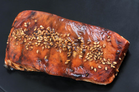 Lacquered salmon with sesame served in a plate close-up