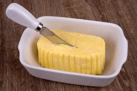 Salted butter in a dish with a knife stuck in it