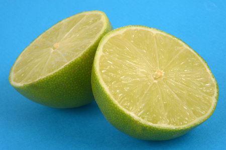 Lime cut in half close-up on blue background