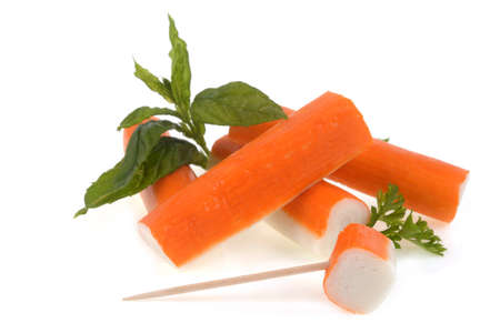 Surimi sticks with with mint leaves and a sprig of parsley close-up on white backgroundの写真素材