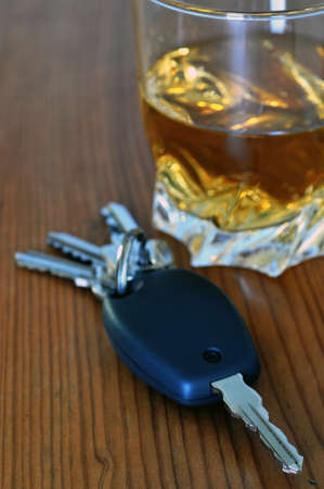 Car key resting next to a glass of whiskeyの写真素材