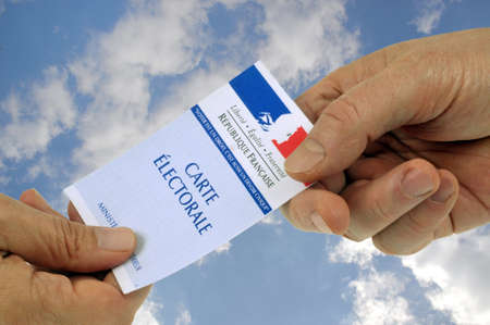 Hand to hand exchange of a French electoral card on white backgroundのeditorial素材