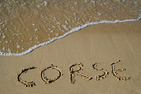 Corsica written in french in the sand of a beachの写真素材