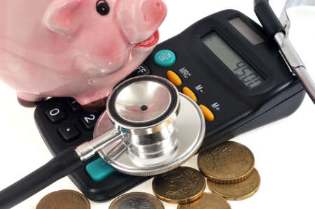 Cost of care concept with a piggy bank resting on a calculator and euros close-up on a white backgroundの写真素材