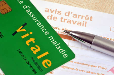 French health insurance card placed on a work stoppage form next to a penのeditorial素材