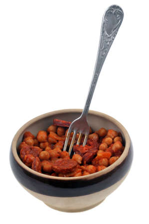 Bowl of chickpeas and chorizo with fork close-up on white backgroundの写真素材