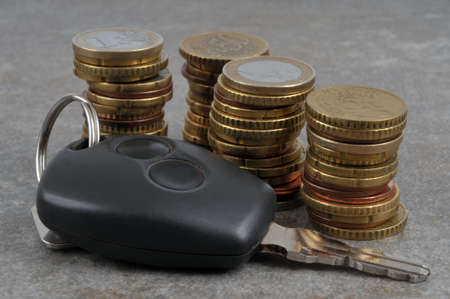 car key and stacks of euro coins close up on gray backgroundの写真素材