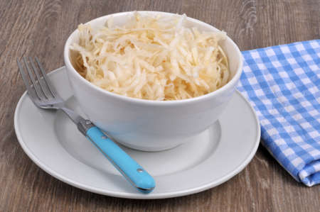 Bowl of grated celeriac with a fork next to a checkered napkinの写真素材