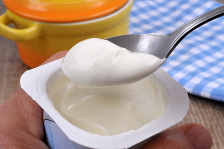 Eating plain yogurt with a spoon close-up
