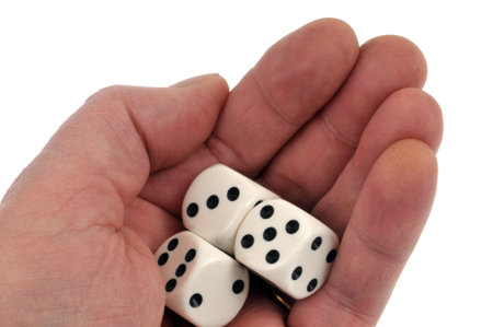 Playing dice in a hand on white background