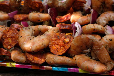 Shrimp chorizo skewers with raw red onions close-upの写真素材