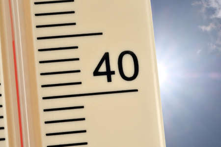 Thermometer indicating 45 degrees centigrade on sunny sky backgroundの写真素材