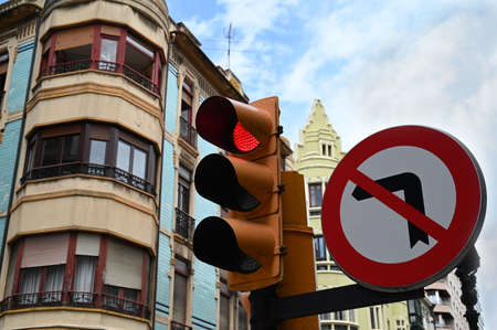 Traffic sign prohibiting turning on the left next to a traffic lightの写真素材