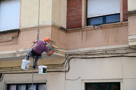 Roped painter working on the facade of a buildingのeditorial素材