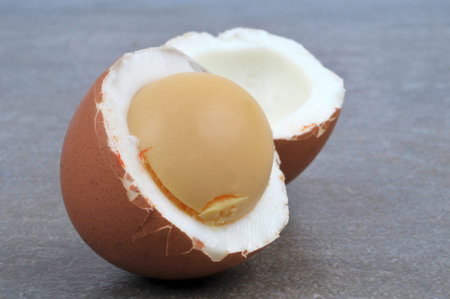 Hard-boiled egg cut in half close-up on gray background
