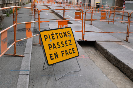Road sign indicating in french to pedestrians to change sidewalks during road works in the city of Vannesのeditorial素材