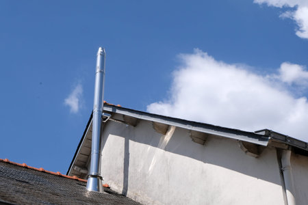 Stainless steel chimney pipe on the roof of a house