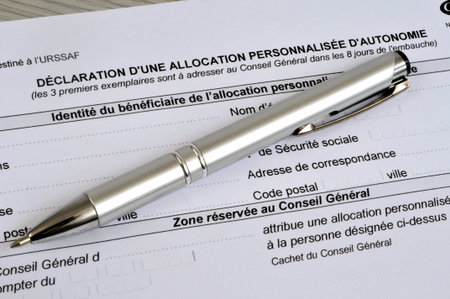 French declaration form for a personalized autonomy allowance with a pen lying on it
