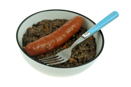 Plate of lentils and sausage with a fork close-up on a white backgroundの写真素材