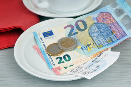 Cash receipt in a saucer with euro banknotes and coinsの写真素材