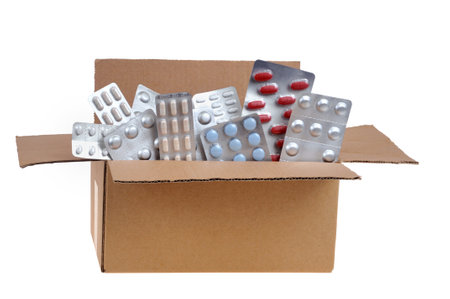 Medicine blister packs in an open carton close-up on a white backgroundの写真素材