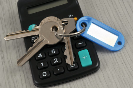 Bunch of keys with a key ring placed on a calculator