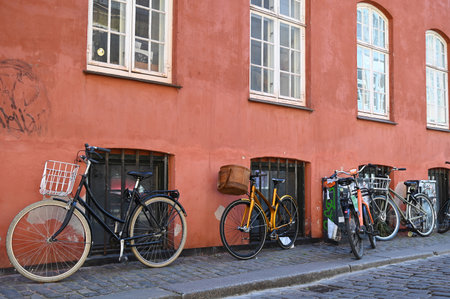 Bicycles leaning against the wall of a house in a street in Copenhagenの写真素材