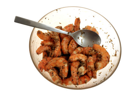 Marinated prawns in a salad bowl with a spoon viewed from above on a white backgroundの写真素材