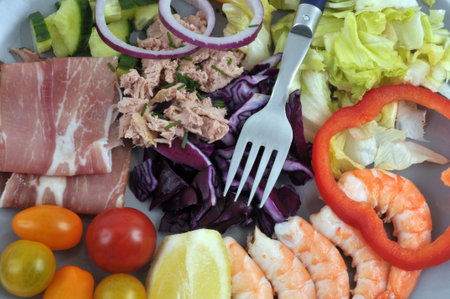 Mixed salad with vegetables, raw ham and prawns close-upの写真素材