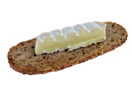 Piece of sheep cheese on a slice of seeded bread close-up on a white backgroundの写真素材