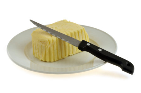 Wafer of salted butter in a plate with a knife close-up on a white backgroundの写真素材