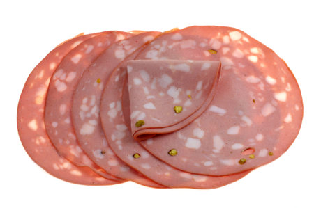 Slices of mortadella with pistachio nuts including one folded close-up on white backgroundの写真素材