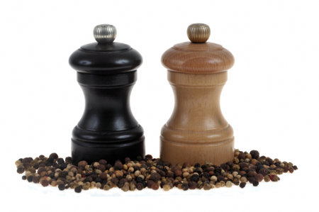 Pepper mills of different colors with peppercorns close-up on white backgroundの写真素材