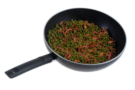 Pan of peas with bacon close-up on white backgroundの写真素材