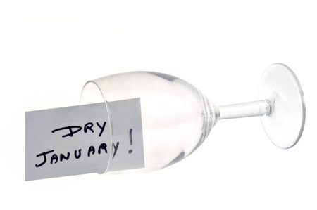 Dry January concept with an overturned empty wine glass and text on a card on a white backgroundの写真素材