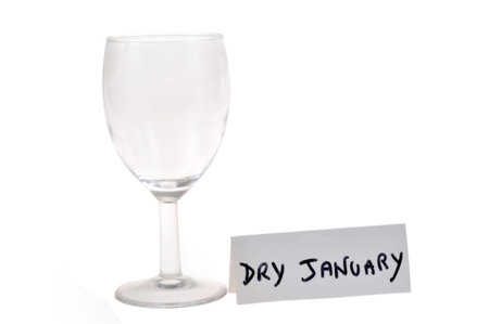 Dry January concept with an empty wine glass and text on a card on a white backgroundの写真素材