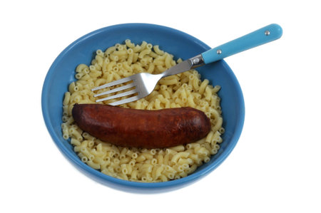 Smoked sausage and pasta with butter on a plate with a fork close-up on a white backgroundの写真素材