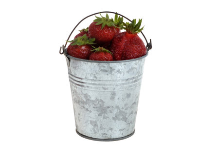 Tin bucket full of strawberries close-up isolated on white backgroundの写真素材