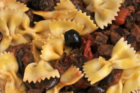 Plate of farfalle with zucchini and black olives closeup on backgroundの写真素材