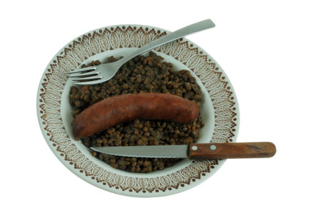 Plate of sausage and lentils with fork and knife top view closeup isolated on white backgroundの写真素材