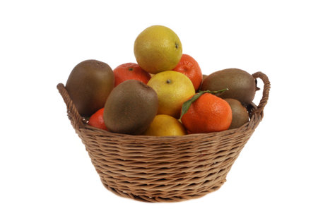 Wicker basket filled with ripe fruits closeup isolated on white backgroundの写真素材
