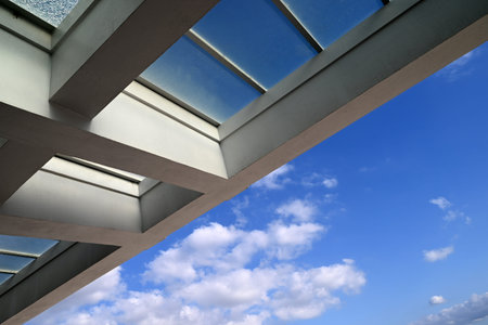Architectural detail of a roof with glass holes and the sky